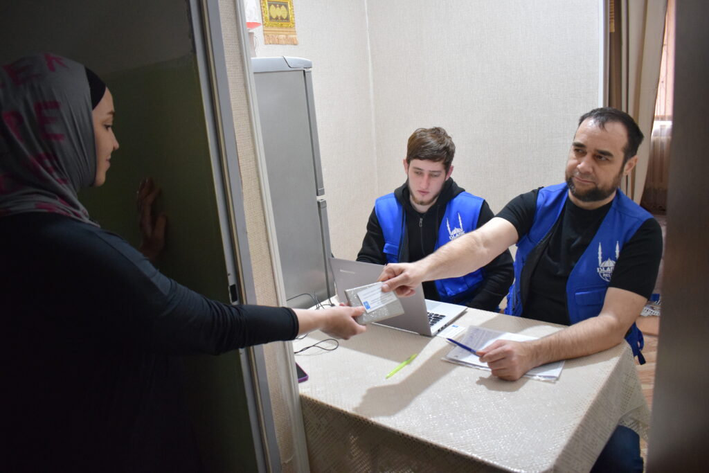 Luiza from Chechnya taking her voucher at a distribution point in the dormitory and at home. 