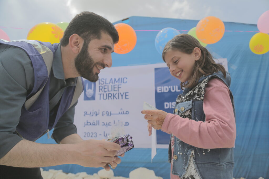 Islamic Relief staff giving girl Eid gifts