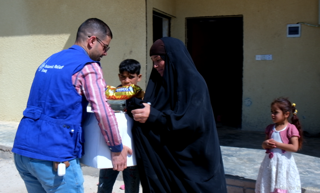 Um Muhammed receiving a food pack from Islamic Relief teams in Iraq during Ramadan 