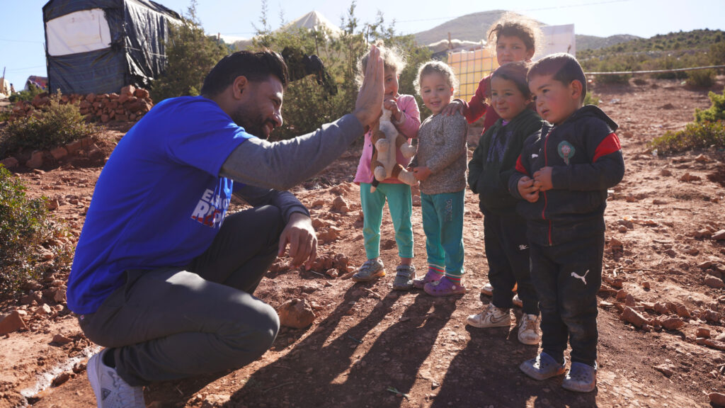 Ghassen Alimi, Islamic Relief’s Head of Mission in Morocco, greets some earthquake affected children receiving support from Islamic Relief