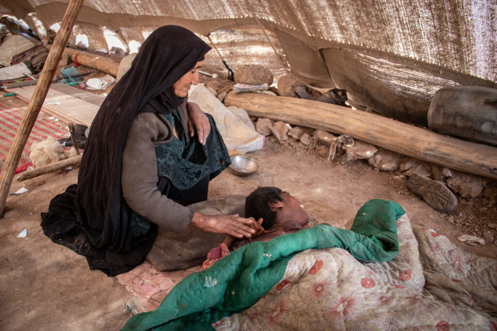 Zainab and her paralysed daughter in their home in Afghanistan, during winter