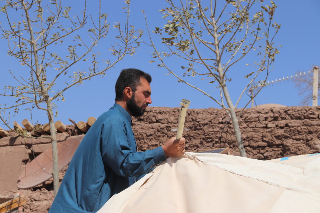 Immamudin, setting up a fallen tent in Botan village, Herat