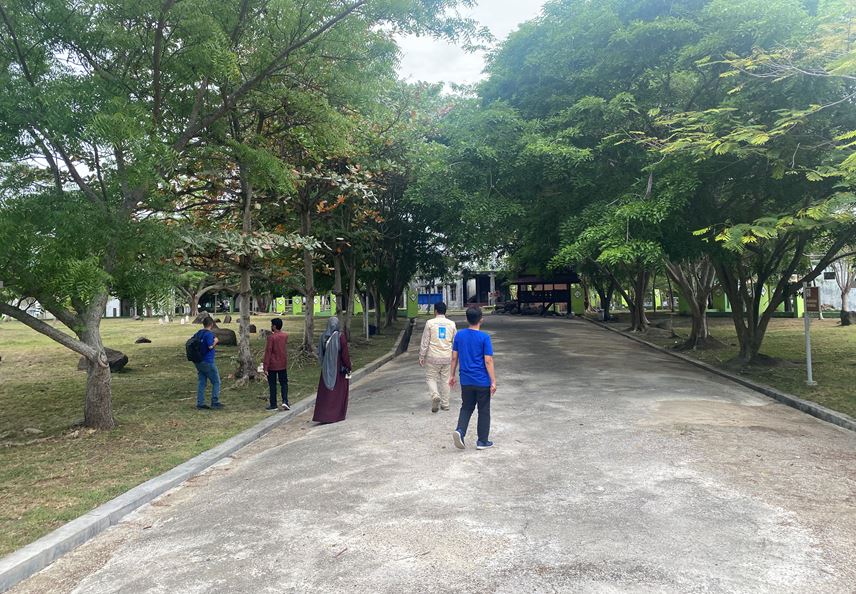 Caption: Candra (second from right) shows Islamic Relief colleagues around one of Banda Aceh’s major mass graves in August 2024