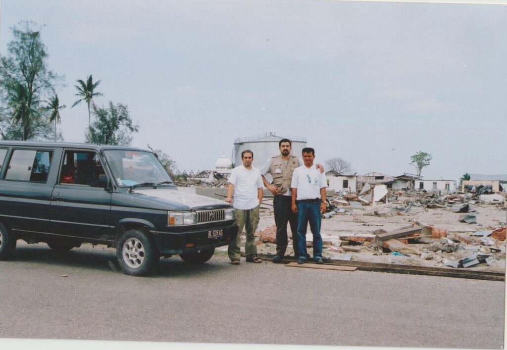 Haroon, Yusuf and Hasballah stand among wreckage from the 2004 tsunami and earthquake