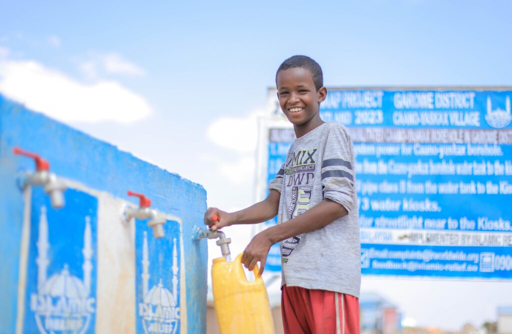 Boy receiving water - a sadaqah jariyah