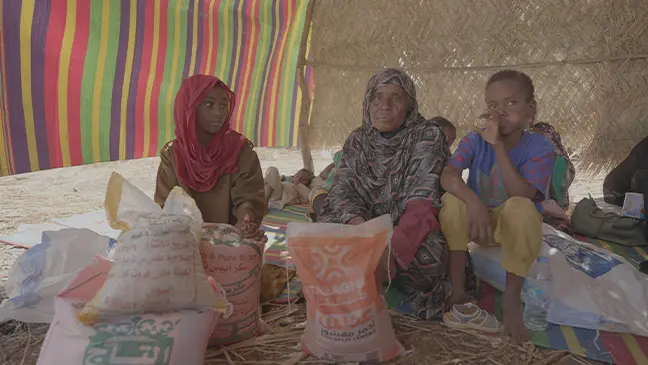 Displaced families gather in a makeshift shelter in Gedaref, Sudan. With no formal camps available, many rely on community support and humanitarian aid to survive.