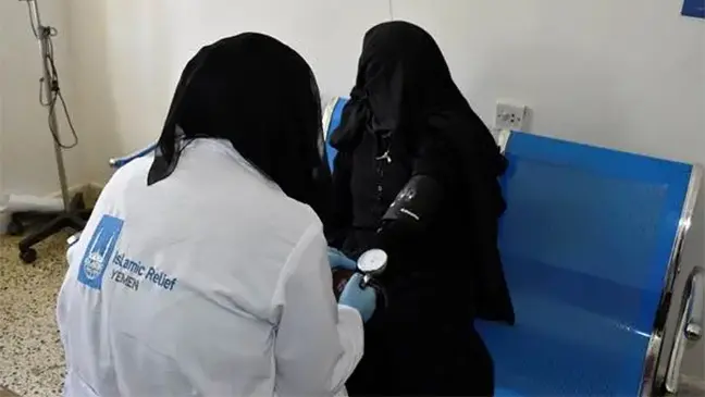 A woman in Yemen receives healthcare support from an Islamic Relief aid worker.