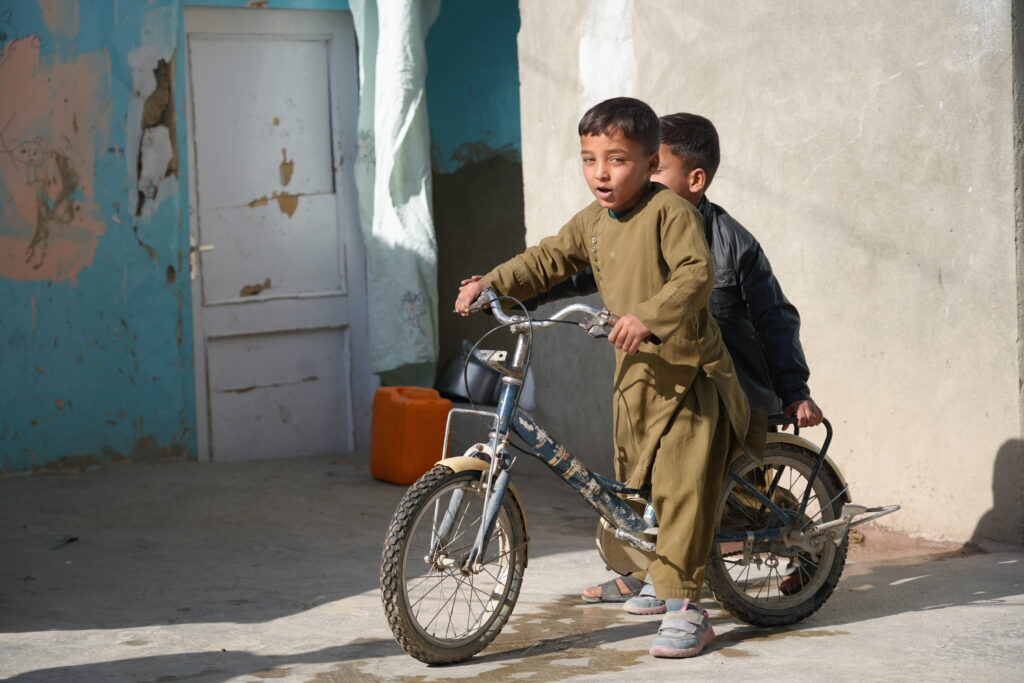Hijran and his eldest brother on the to-rent tricycle Hijran's mother bought with the orphan care support 