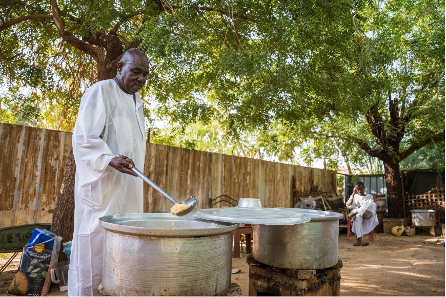Mohamed at the Al-Thawra community kitchen in Khartoum, preparing food servings.