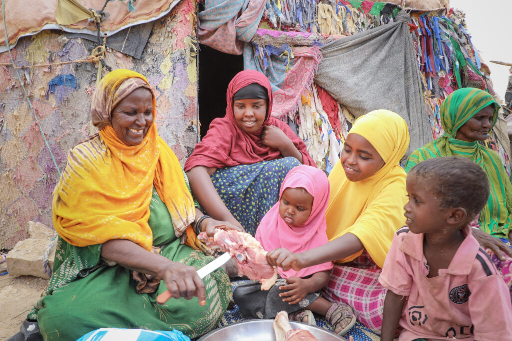 Women-led family receiving Qurban meat and lady feeding it to children for Eid Al Adha during Dhul Hijjah