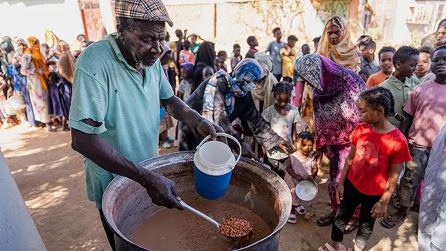 Families queue up to receive food.