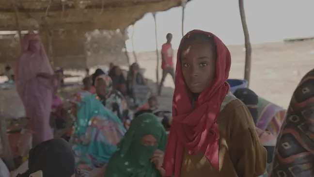 A girl stands among Overcrowded living conditions in a displacement camp. Limited sanitation and scarce resources have led to disease outbreaks among vulnerable families